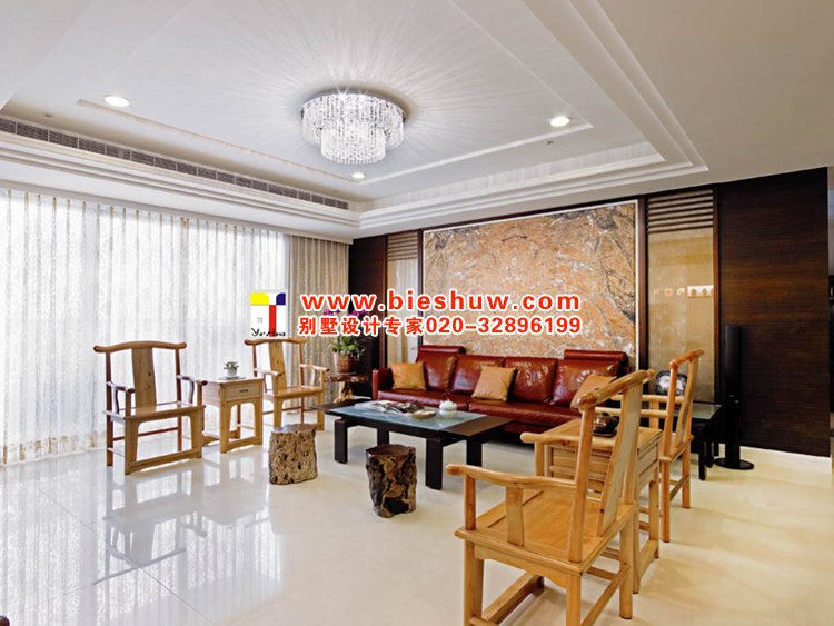 客厅采用传统的中式桌椅及茶几，沙发背景墙是一大亮点，特选珍稀的天然树纹大理石，配上精美的艺术画框，就像一幅华美的抽象画作